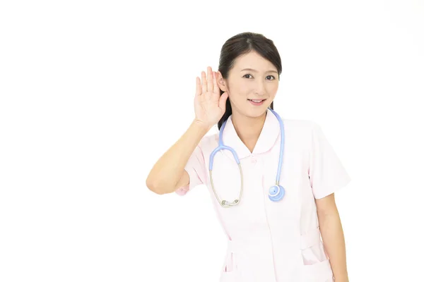 女性看護師は 彼女の耳に彼女の手を置く — ストック写真