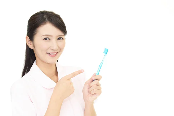 Smiling Dental Hygienist Pointing — Stock Photo, Image