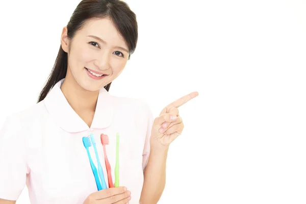 Smiling Dental Hygienist Pointing — Stock Photo, Image