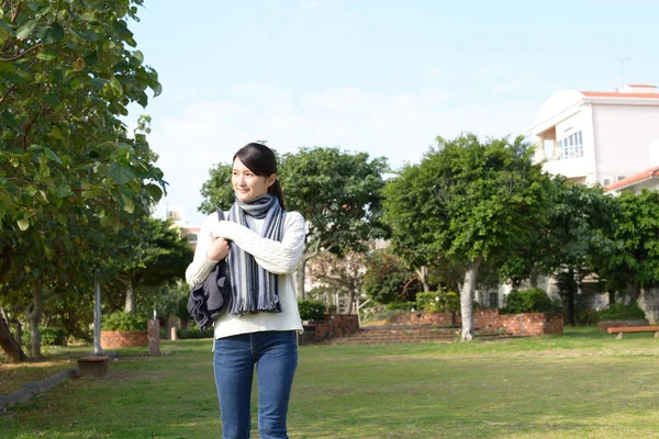 Genç bayan parkta dinleniyor.