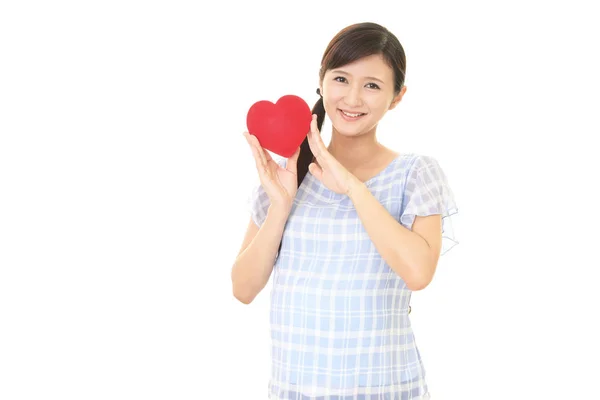 Kırmızı Kalp Aşk Sembolü Tutan Gülümseyen Hamile Kadın — Stok fotoğraf