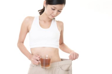 Ayakta ve kilo kaybetme sonra çok büyük pantolon giyen kadın