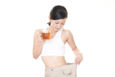 Ayakta ve kilo kaybetme sonra çok büyük pantolon giyen kadın