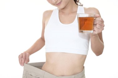 Ayakta ve kilo kaybetme sonra çok büyük pantolon giyen kadın