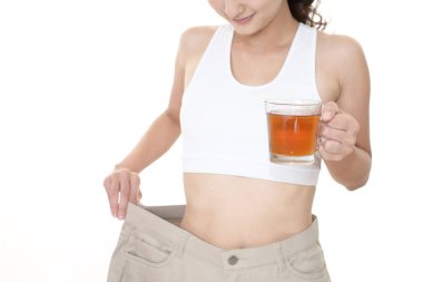 Ayakta ve kilo kaybetme sonra çok büyük pantolon giyen kadın