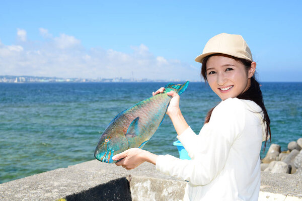 Smiling young woman holding big fish