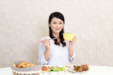 Genç bayan kahvaltı yapıyor.