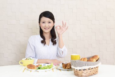 Genç bayan kahvaltı yapıyor.