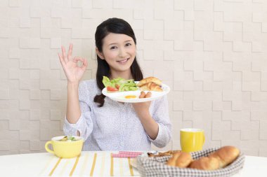 Genç bayan kahvaltı yapıyor.