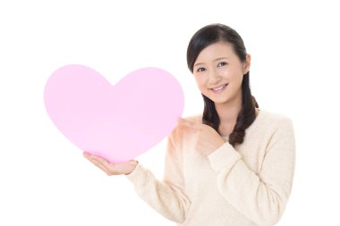 Gülümseyen kadın holding pembe kalp aşk sembolü