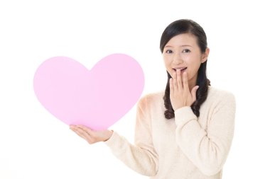 Gülümseyen kadın holding pembe kalp aşk sembolü