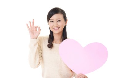 Gülümseyen kadın holding pembe kalp aşk sembolü