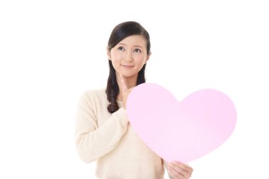 Gülümseyen kadın holding pembe kalp aşk sembolü