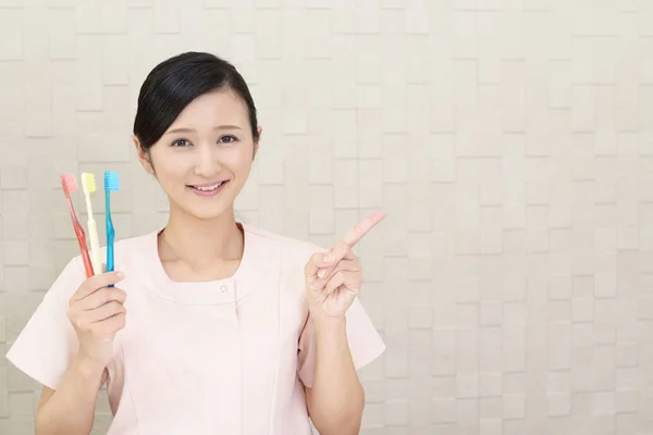 Smiling Dental Hygienist Pointing — Stock Photo, Image