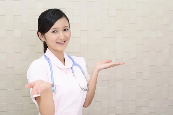 女护士在她的手掌上显示的东西 — 图库照片