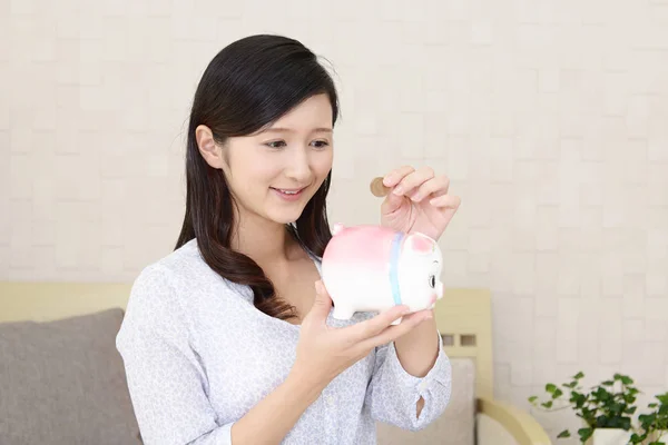 Smiling woman holding a piggy bank