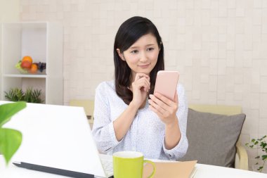 Bir akıllı telefon kullanan gülümseyen kadın