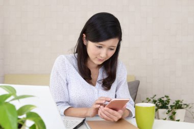 Bir akıllı telefon kullanan gülümseyen kadın