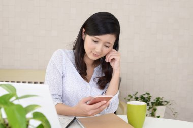 Bir akıllı telefon kullanan gülümseyen kadın