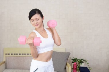 Güzel ince kadın dumbbells ile