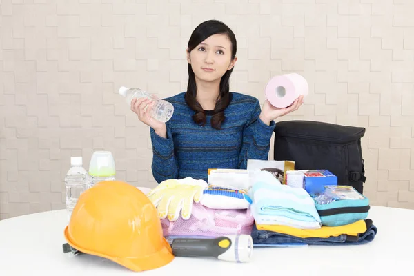 Uneasy woman with emergency preparedness kit