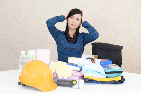 Uneasy woman with emergency preparedness kit