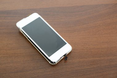 Masanın üzerinde kırık akıllı telefon