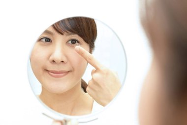 Kontakt lens işaret parmağı üzerinde tutan kadın