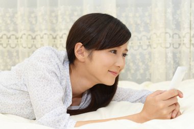 Bir akıllı telefon kullanan gülümseyen kadın