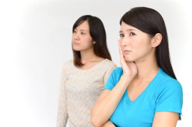 Beyaz arka plan ile endişeli görünümlü iki kadın