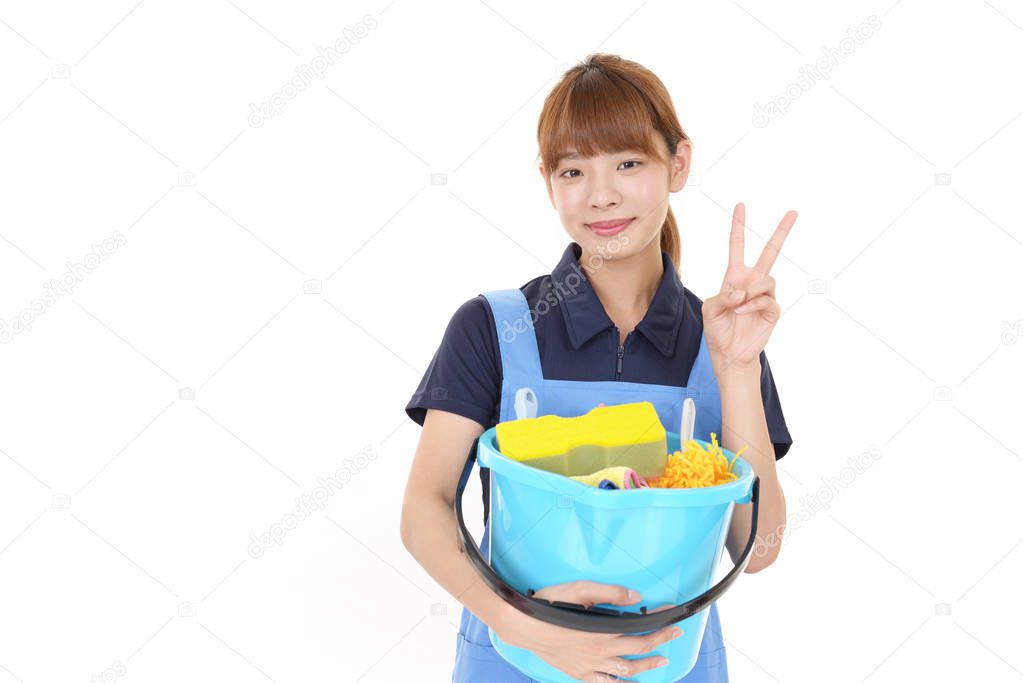 Smiling woman posing with cleaning supplies on white background
