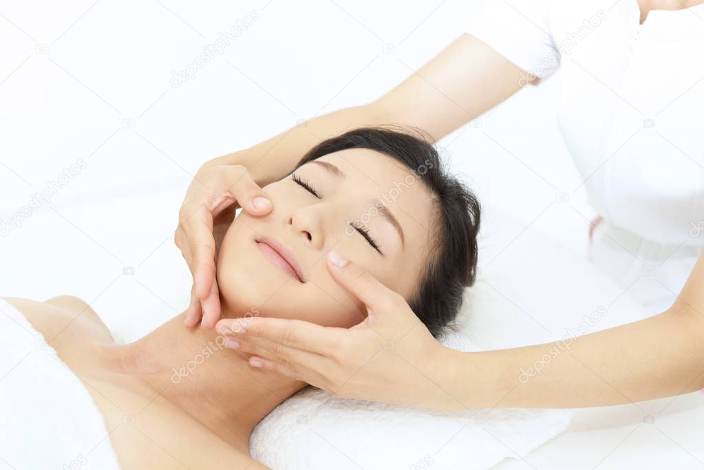 Beautiful young woman receiving facial massage