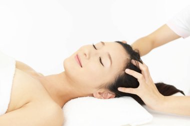 Spa salonundaki kadın kafa masajı yaptırıyor.