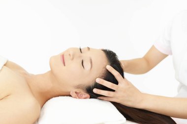 Spa salonundaki kadın kafa masajı yaptırıyor.