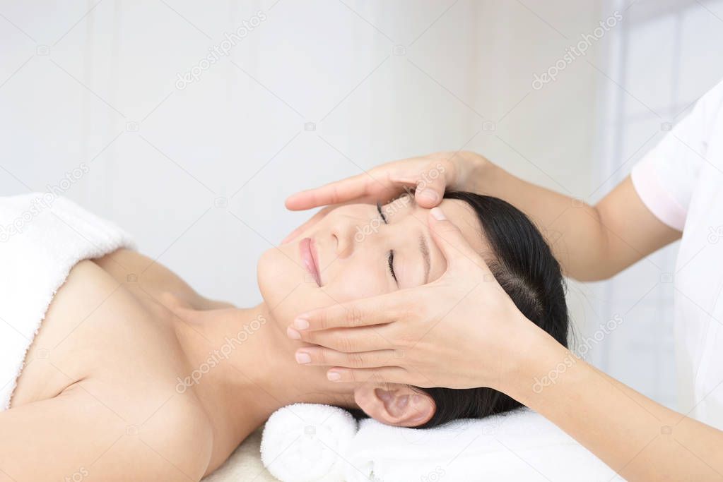 Beautiful young woman receiving facial massage
