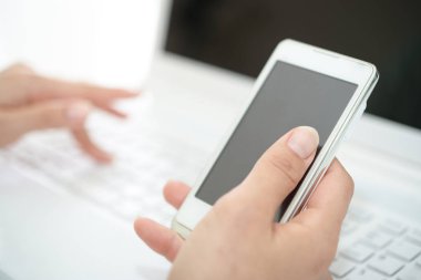Akıllı telefon ve dizüstü bilgisayar kullanarak yakın çekim kadın elleri