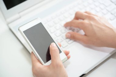 Akıllı telefon ve dizüstü bilgisayar kullanarak yakın çekim kadın elleri