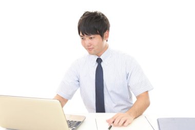 bir dizüstü bilgisayar kullanarak gülümseyen iş adamı