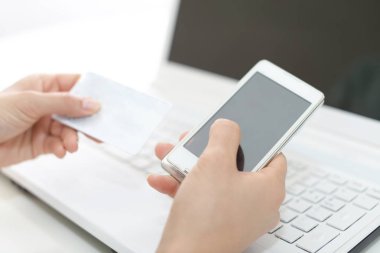 Kadın eli kredi kartı ve akıllı telefonlu.