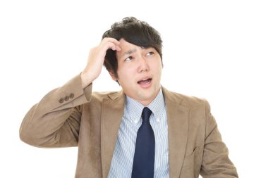 Şaşırmış Asyalı işadamı beyaz arka planda izole edilmiş.