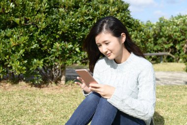 Genç bayan parkta dinleniyor.