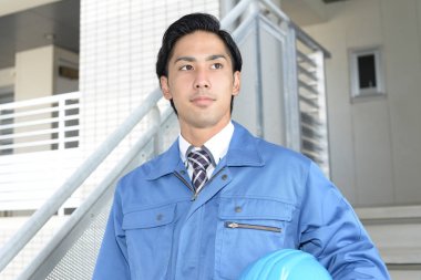 Asya adam işçi giyiyor mavi üniforma gülümseyen