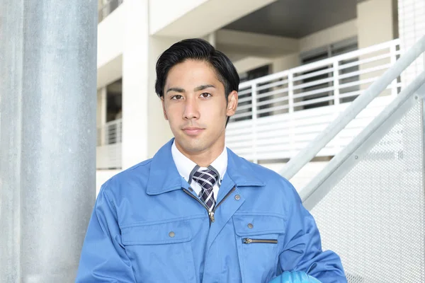 Smiling Asian man worker wearing blue uniform