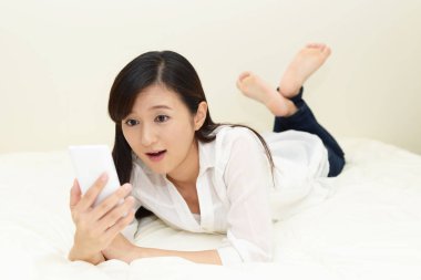 Bir akıllı telefon kullanan gülümseyen kadın