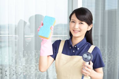 Gülümseyen kadın temizlik aletleriyle