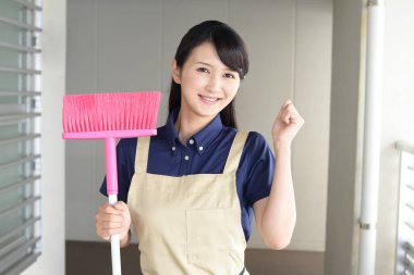 Gülümseyen kadın temizlik aletleriyle