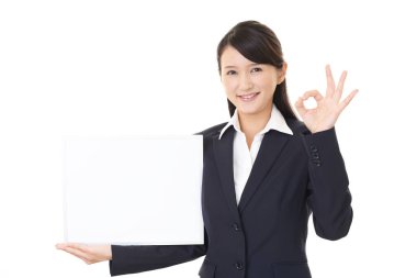 Gülen kadın elinde beyaz bir tahta tutuyor.