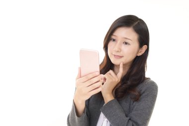 Akıllı telefon kullanan gülümseyen bir kadın.