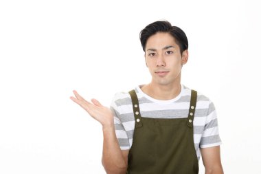 Önlük takan genç bir adam yön tarif ediyor.