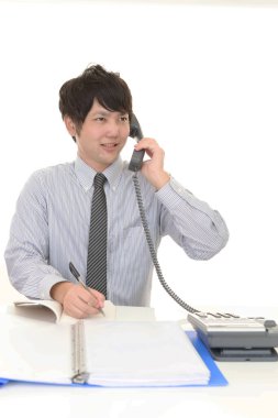 Ofis çalışanı telefonda konuşuyor.